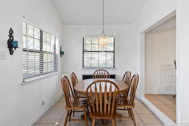 dining area featuring light tile patterned floors, lofted ceiling, plenty of natural light, and a notable chandelier