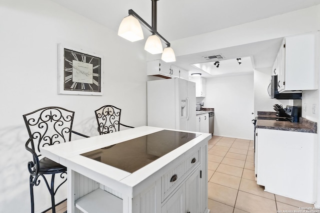 kitchen with pendant lighting, white appliances, white cabinetry, and light tile patterned floors