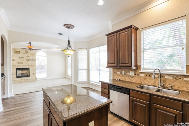 kitchen featuring stainless steel dishwasher, plenty of natural light, sink, and a center island