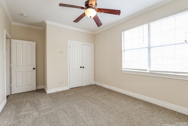 unfurnished bedroom with ceiling fan, light carpet, a closet, and crown molding