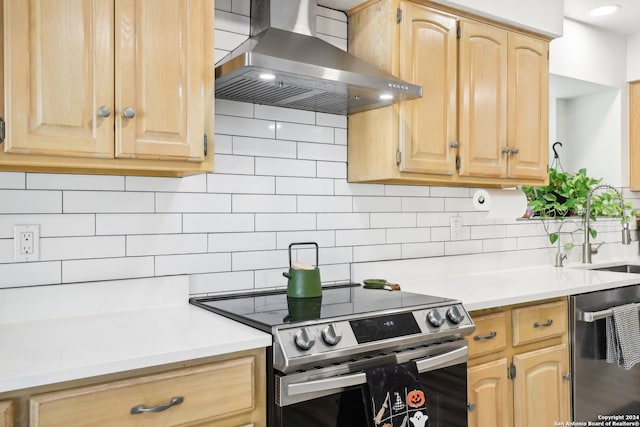 kitchen featuring appliances with stainless steel finishes, light brown cabinets, sink, decorative backsplash, and wall chimney exhaust hood