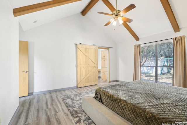 bedroom featuring hardwood / wood-style flooring, beamed ceiling, ceiling fan, high vaulted ceiling, and a barn door