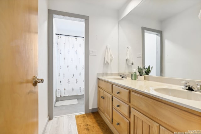 bathroom with walk in shower, wood-type flooring, and vanity