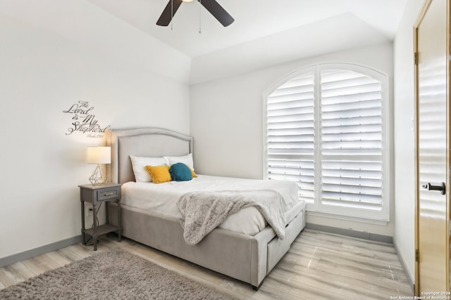 bedroom with light wood-type flooring, ceiling fan, and vaulted ceiling