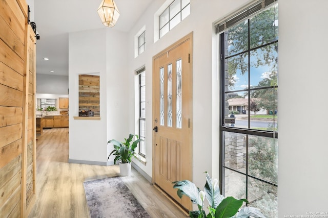 entryway featuring a barn door and light hardwood / wood-style floors