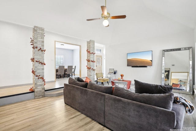 living room featuring light hardwood / wood-style floors, ceiling fan, and vaulted ceiling