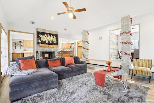 living room with a brick fireplace, hardwood / wood-style floors, ornamental molding, and ceiling fan