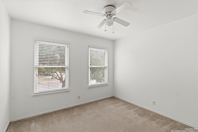 spare room with light colored carpet and ceiling fan