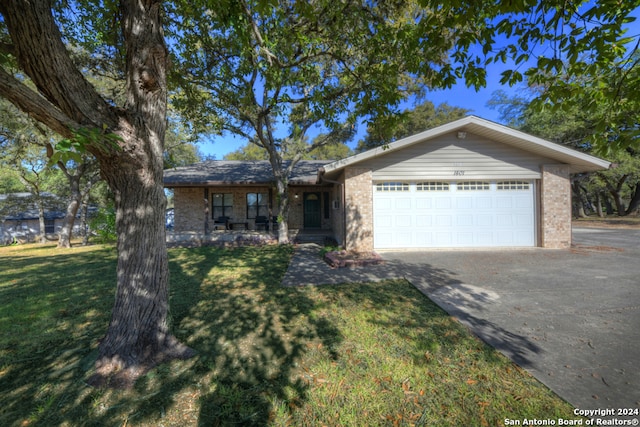 ranch-style house featuring a garage and a front yard