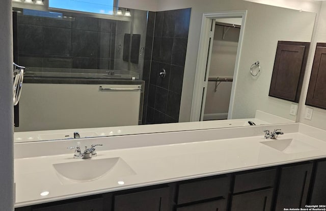 bathroom with vanity and a tile shower