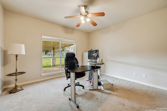 carpeted home office featuring ceiling fan