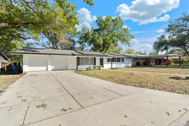 ranch-style house featuring a garage, a front yard, and solar panels