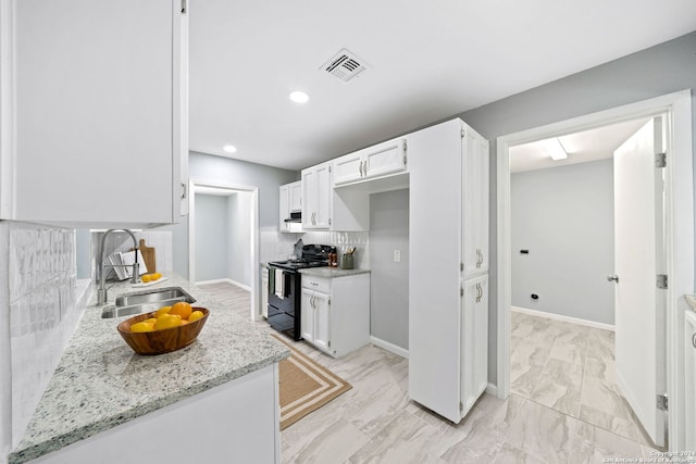 kitchen with light stone counters, white cabinets, sink, tasteful backsplash, and black electric range oven