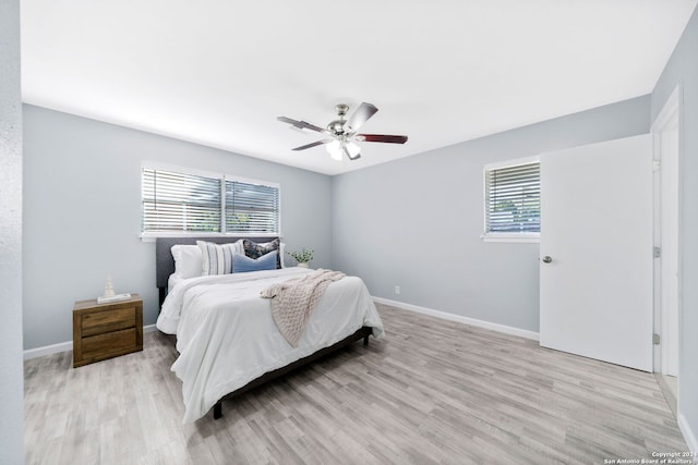 bedroom with light wood-type flooring, multiple windows, and ceiling fan