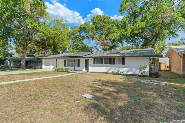 single story home featuring a front lawn, solar panels, a porch, and central air condition unit