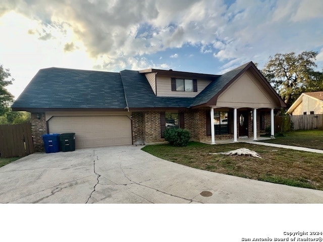 view of front of house featuring a garage, a front yard, and a porch