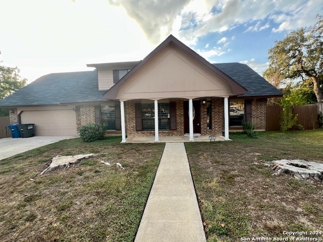 view of front of property featuring a front lawn, a garage, and a porch