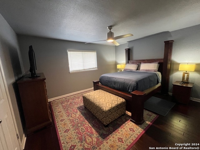 bedroom with a textured ceiling, dark hardwood / wood-style floors, and ceiling fan