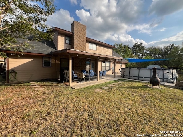 rear view of property with a lawn and a patio