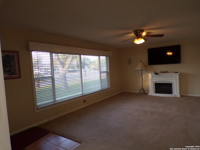 unfurnished living room with ceiling fan and carpet flooring