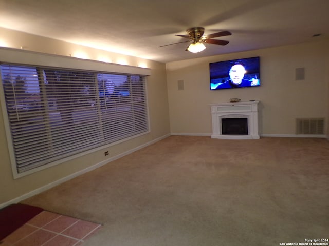 unfurnished living room with ceiling fan and carpet floors