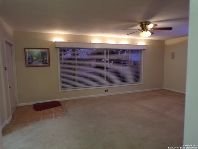 unfurnished room featuring light colored carpet and ceiling fan