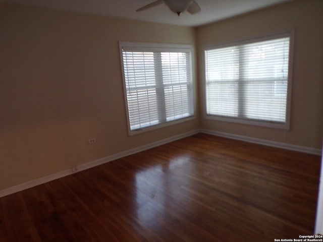 empty room featuring ceiling fan and dark hardwood / wood-style flooring