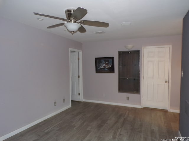 empty room with dark hardwood / wood-style flooring and ceiling fan