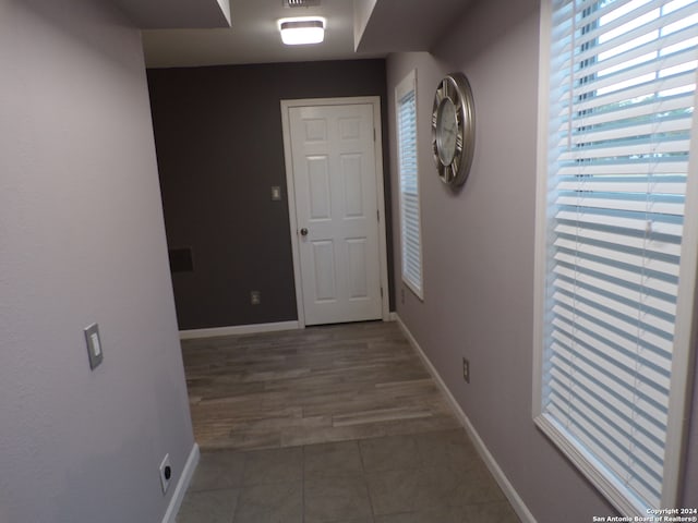 hall featuring dark tile patterned flooring