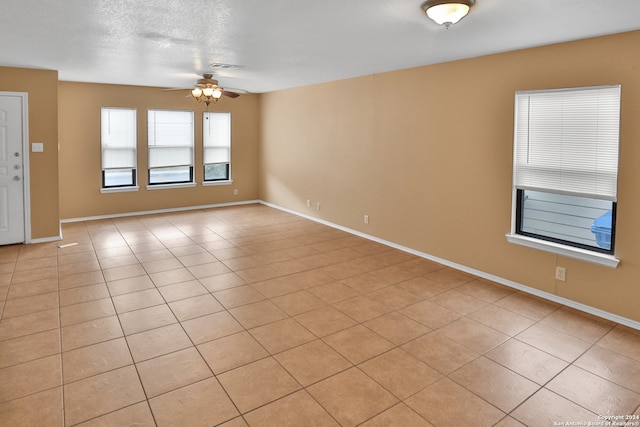 tiled spare room featuring ceiling fan and a textured ceiling