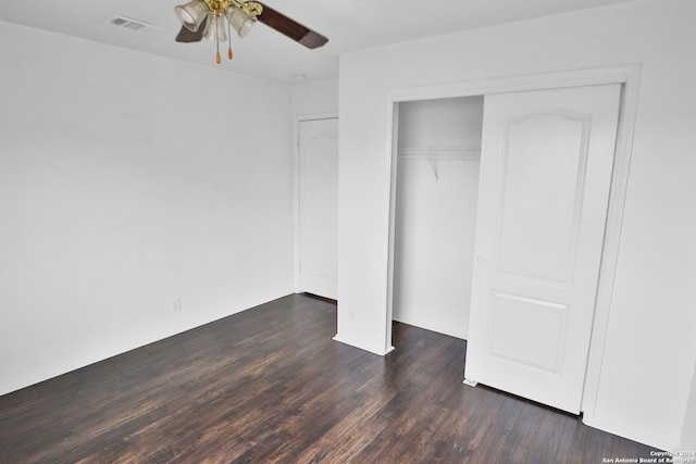 unfurnished bedroom featuring dark wood-type flooring, a closet, and ceiling fan