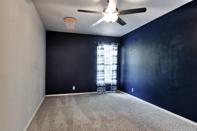 carpeted empty room with ceiling fan and a textured ceiling