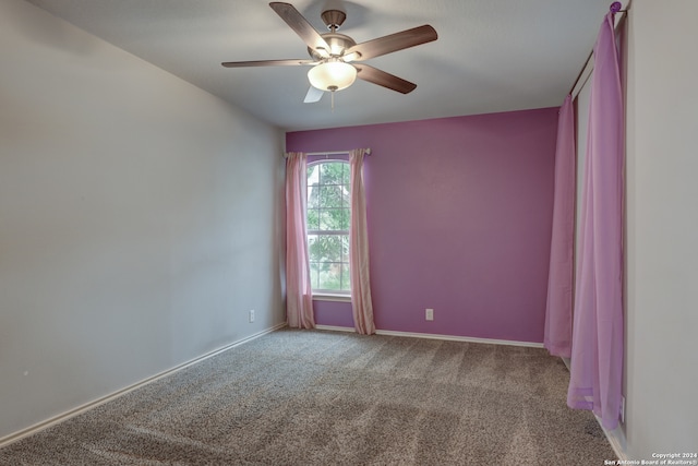 spare room with light colored carpet and ceiling fan