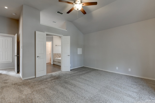 unfurnished bedroom with dark colored carpet, ensuite bath, ceiling fan, and vaulted ceiling