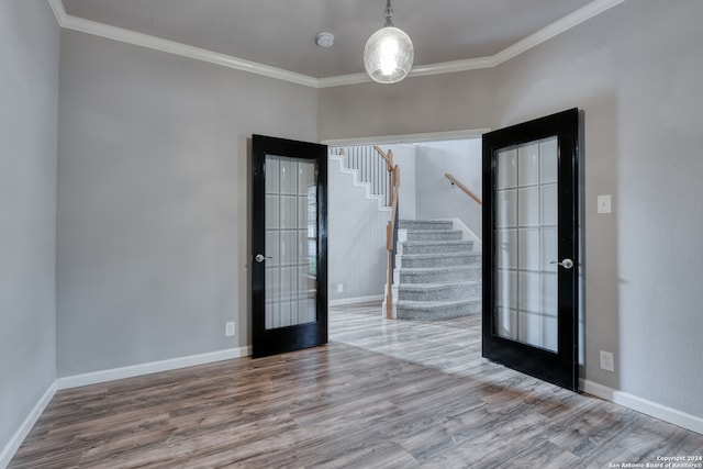 empty room with french doors, hardwood / wood-style flooring, and ornamental molding