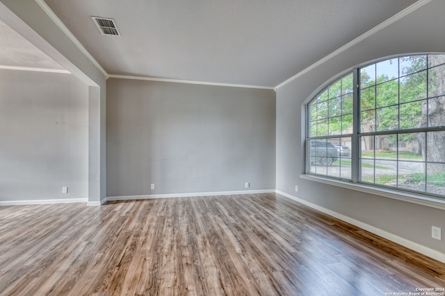 unfurnished room with hardwood / wood-style flooring and ornamental molding