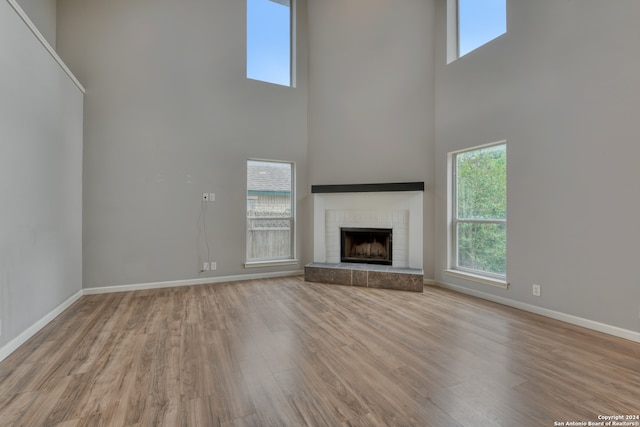 unfurnished living room with a towering ceiling and light hardwood / wood-style flooring