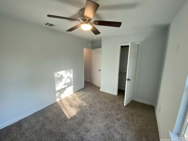 unfurnished bedroom with a closet, ceiling fan, and dark carpet