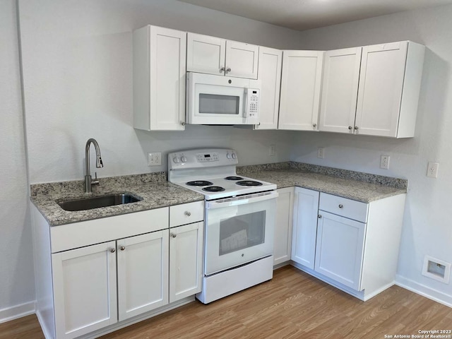 kitchen with white appliances, sink, and white cabinets