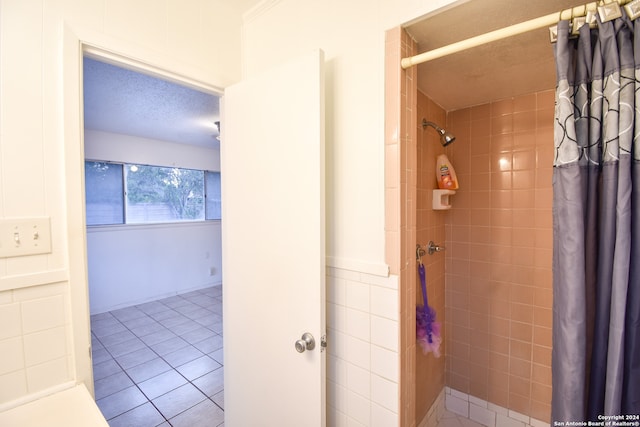 bathroom featuring a shower with curtain, tile walls, a textured ceiling, and tile patterned flooring