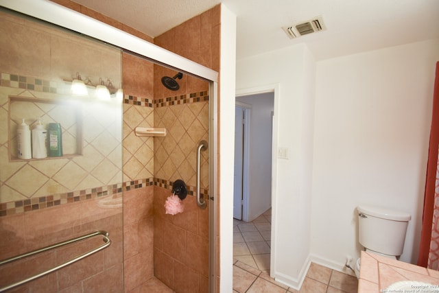 bathroom featuring tile patterned flooring, an enclosed shower, and toilet