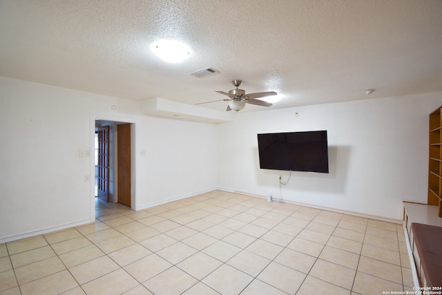 tiled empty room featuring a textured ceiling and ceiling fan