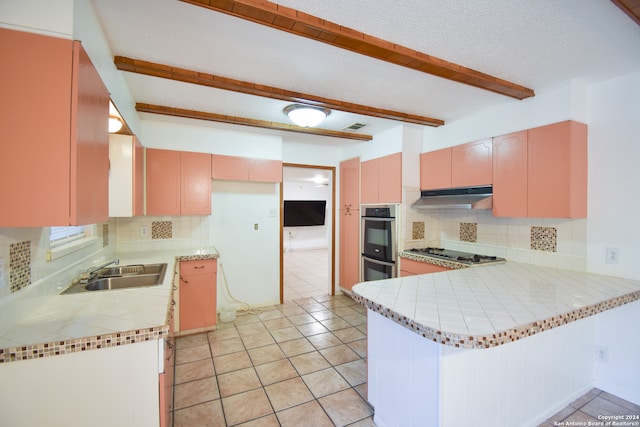 kitchen with stainless steel appliances, decorative backsplash, kitchen peninsula, sink, and beam ceiling