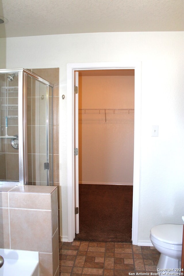 bathroom featuring walk in shower and toilet