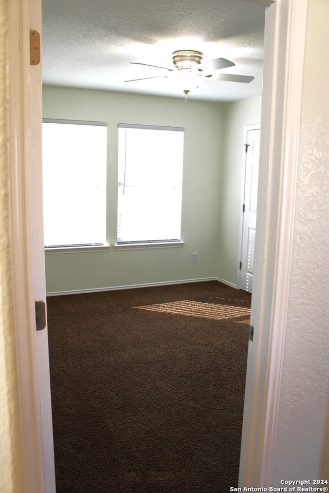 spare room with carpet, a textured ceiling, and ceiling fan