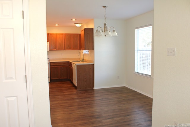 kitchen with sink, hanging light fixtures, white appliances, a chandelier, and dark hardwood / wood-style flooring