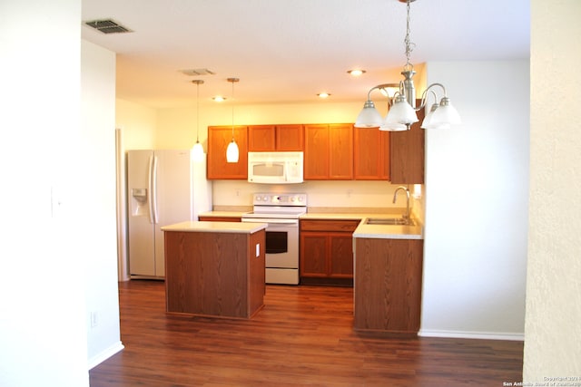 kitchen featuring white appliances, sink, decorative light fixtures, and a kitchen island