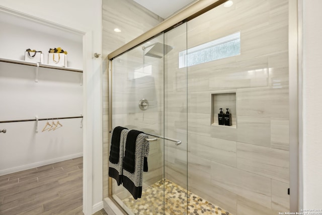 bathroom featuring wood-type flooring and a shower with door