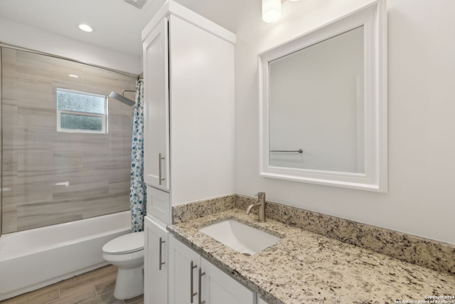 full bathroom with hardwood / wood-style floors, shower / tub combo with curtain, vanity, and toilet