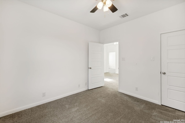 carpeted spare room with ceiling fan